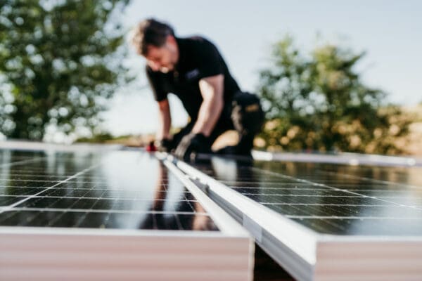 Technicus die een zonnepaneel op een dak legt